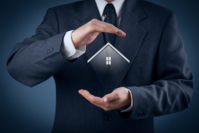 property insurance and security concept. protecting gesture of man and symbol of house. 