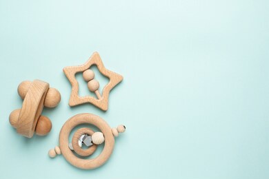 wooden baby toy rattle on light blue background, natural eco materials and early baby development
