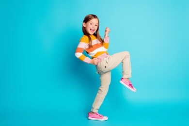 full length body size profile side view of her she nice attractive pretty lucky glad cheerful cheery girl celebrating great success isolated over bright vivid shine vibrant blue color background