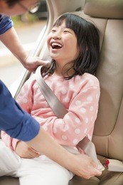 father take care daughter to fasten a seat belt