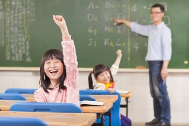 asian pupils raising hands during the lesson 