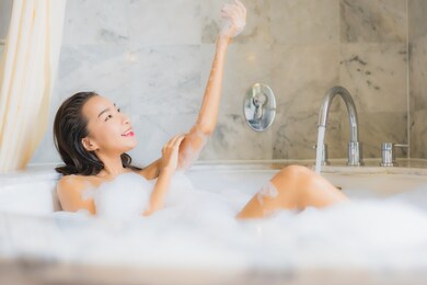 portrait beautiful young asian woman relax take a bath in bathtub in bathroom interior