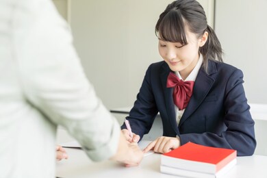 asian female high school student and teacher in classroom. cram school. preparatory school. home tutor.