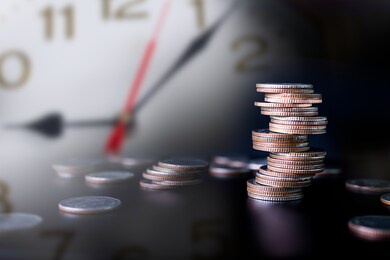 future plan saving money for 2021 year concept. double exposure of stack coins with clock on dark black background.