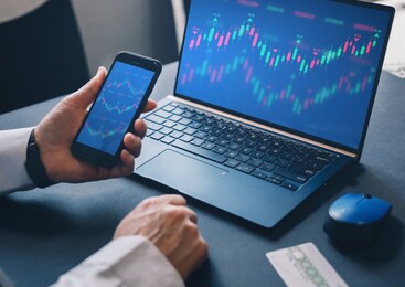 businessman using  laptop computer with financial graphs and statistics on monitor. technical price candlestick chart graph and indicator stock online trading. forex investment business. 