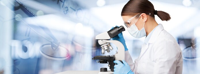 young female scientist standing with medical microscope