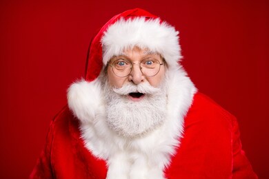 photo of retired old man grey beard open mouth excited look see magical newyear creature make wish bring atmosphere wear santa costume coat spectacles headwear isolated red color background
