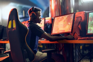 cybersport concept. side view of a focused african guy, professional gamer wearing headphones participating in esport tournament