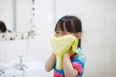 young girl washing face by herself  in bathroom 