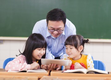 teacher teaching  children with digital tablet or ipad