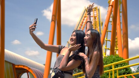 asian friends taking a selfie at the amusement park