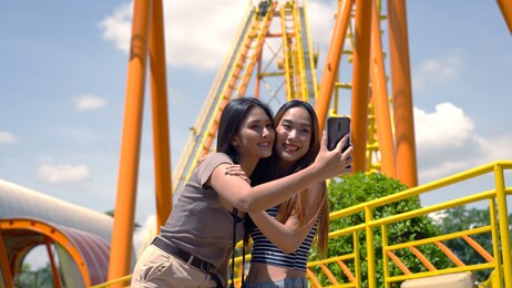 asian friends taking a selfie at the amusement park