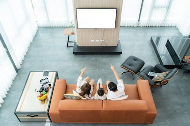 top view of asian happy family sitting and watching television in living room at home and spent quality time together for activity in vacation day, holiday, happiness or lifestyle concept.