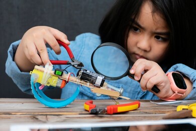 a cute asian girl is learning to assemble a robot during school hours, a start to learn innovation.