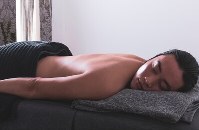 asian man in wellness beauty spa having aroma therapy massage with essential oil, looking relaxed