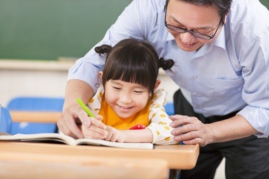 teacher teaches a student to using a pencil