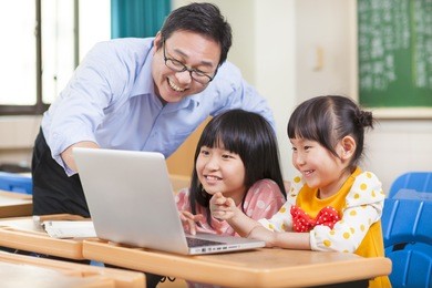 teacher teaching  children with a laptop
