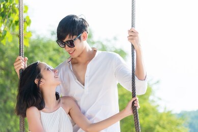 smiling lifestyle asia couples lover and happy on the hammock. people woman and man relax and romantic honeymoon in luxury resort near the beach. summer travel concept.