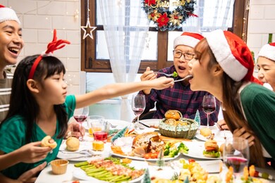 thanksgiving or christmas celebration asian  family dinner concept.family having holiday dinner.happy family cooking for party. father mother and daughter, having dinner at home. 