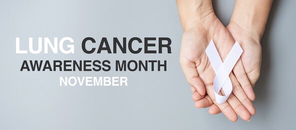november lung cancer awareness month, .man holding white ribbon on grey background