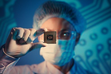 computer engineer holding microchip for detailed analysis on the foreground 