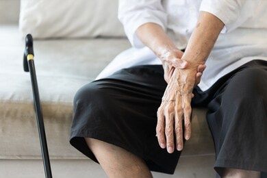 close up view on the shaking hand of the senior woman,symptom of resting tremor or parkinson's disease,old elderly patient holding her wrist to control hand tremor,neurological disorders,brain problem