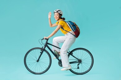 asian beautiful woman, she is riding a city bike to work.she is greeting.studio concept