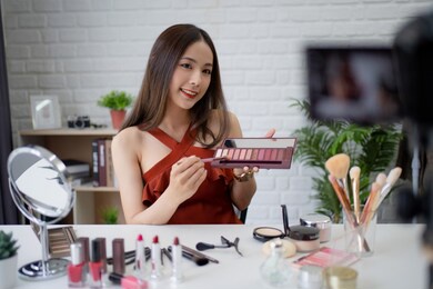 beautiful asian blogger is teaching makeup while recording a video with a camera to share on social media.