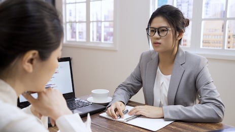 skeptical unconvinced asian chinese hr manager woman asking questions about cv at bad job interview in cafe restaurant.