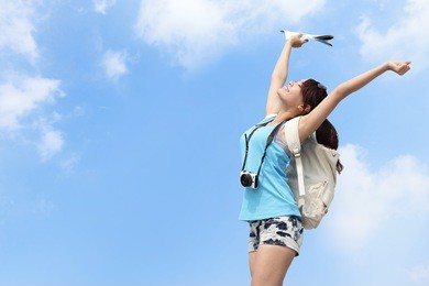 happy woman traveler relax feel free with sky background