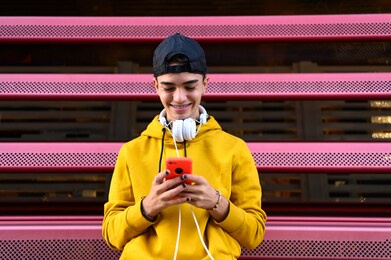 happy guy using a smart phone to listen music with headphones