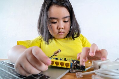 asian women are learning simple electrical circuits. by learning from the laptop searching for information on how to connect the circuit