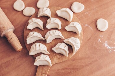 cooking homemade dumplings or ravioli with meat on the table. women's hands make dumplings. traditional russian dumplings. culinary concept. step-by-step instructions for cooking dumplings.