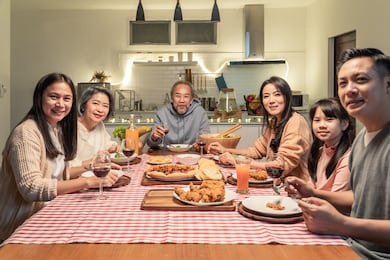 happy family time and relationship, asian big family having small christmas party eating food together at home. kid is happy to see parent, cousin preparing food and bring it to dining table at home.