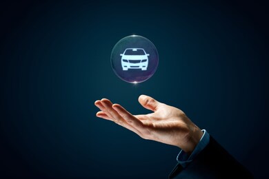 dream about new car, carsharing, car rental and leasing concepts. hand with soap bubble (symbol of dream) with symbol of the car inside.