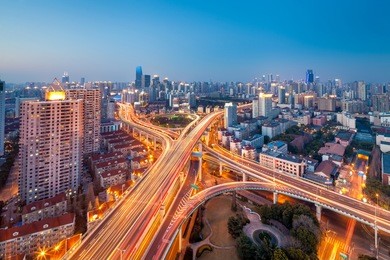 shanghai traffic at night , interchange overpass and elevated road with modern city skyline