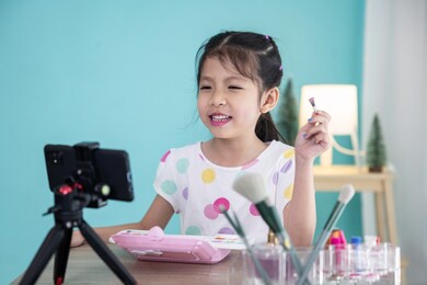 happy little asian girl beauty vlogger or blogger recording video for teaching to use cosmetic make up.