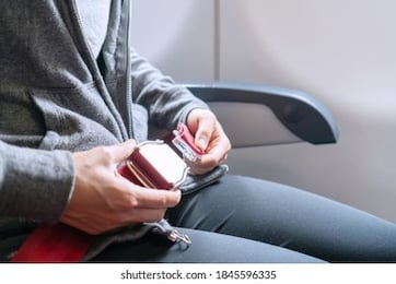 hands of asian woman passenger fastening seat belt while sitting on the airplane before airplane taking off for safe flight. safety travel concept.