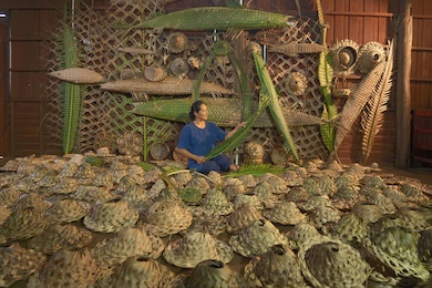 old asian woman making thai local woven straw hat or cap from leaves from natural palm trees product, thailand. weaving in market. old traditional lifestyle. handmade.