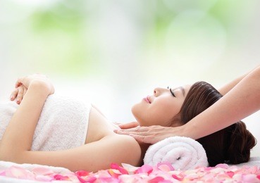relax beautiful woman face receiving massage with nature green background, asian beauty