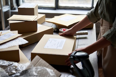 female distribution warehouse worker or seller packing ecommerce shipping order box for dispatching, preparing post courier delivery package, dropshipping commerce retail shipment service concept.