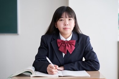 a japanese junior high school girl studies in the classroom with a straight face