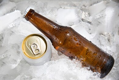 beer bottle with beer can chilled in ice