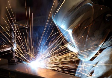 a welder welding the top on a pressure vessel.