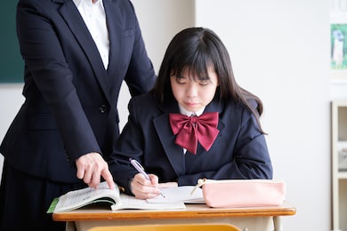 a japanese junior high school girl is taught by her teacher in the classroom