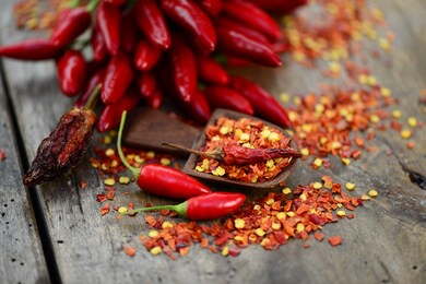 red chili, fresh and dry seeds on wooden background, closeup.