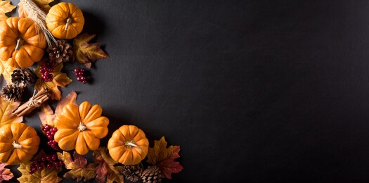 thanksgiving background decoration from dry leaves,red berries and pumpkin on blackboard background. flat lay, top view with copy space for autumn, fall, thanksgiving concept.