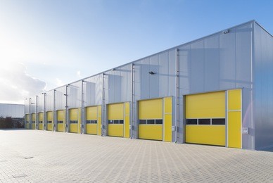 exterior of a commercial warehouse with yellow roller doors