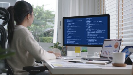back rear view of young asian woman, freelance data scientist work remotely at home coding programing on big data mining, ai data engineering, it technician works on artificial intelligence project.