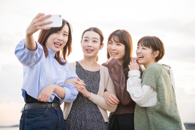 4 women taking a commemorative photo with a smartphone